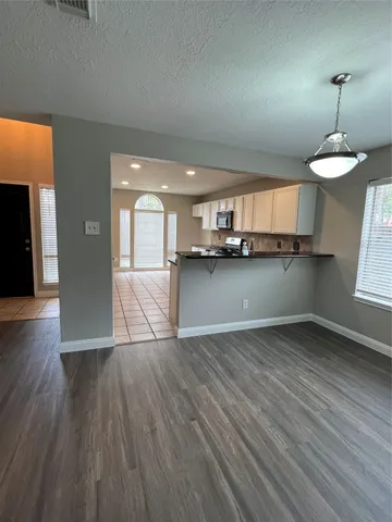 a view of a kitchen with wooden floor and a window