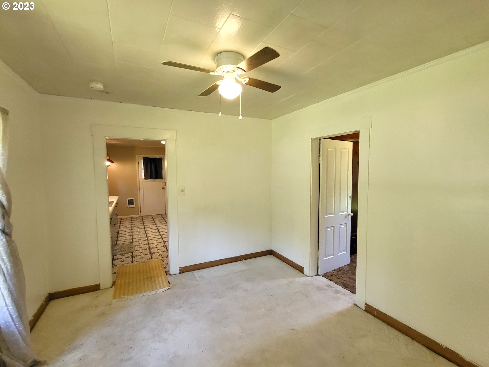 1001 Curtin Road Cottage Grove, OR 97424 - Photo 8 of 24 an empty room with a ceiling fan and a window