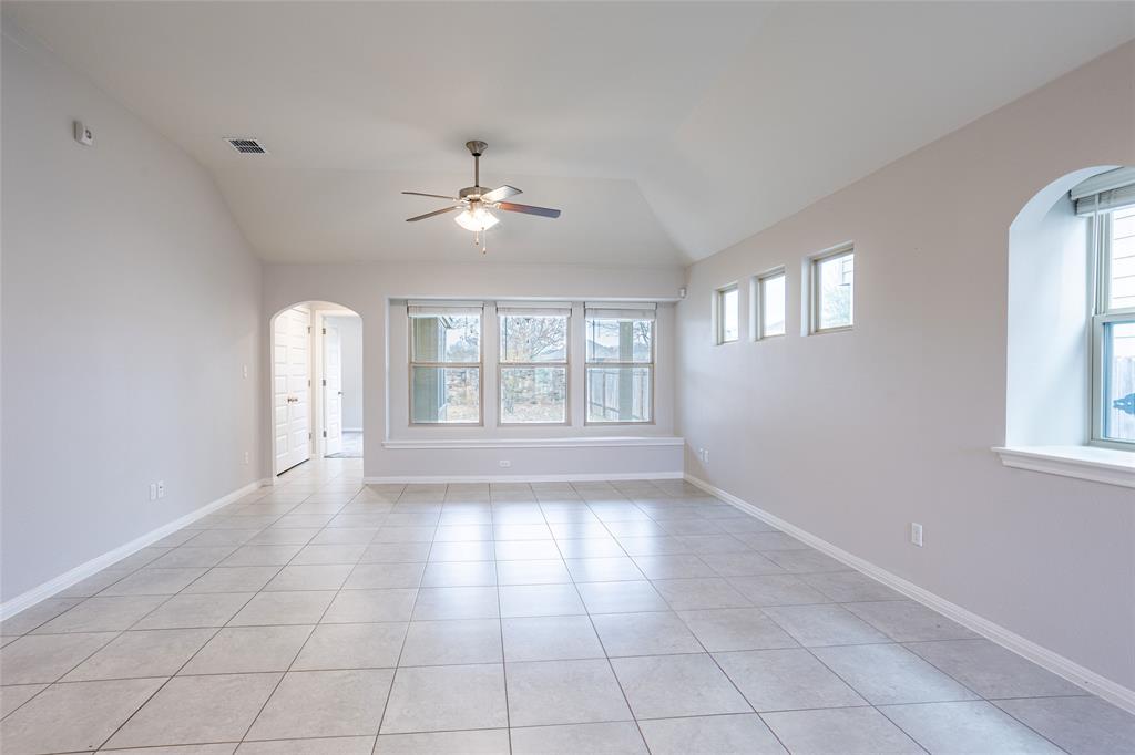 615 Stampede Road San Marcos, TX 78666 - Photo 17 of 26 Vast tile flooring leads to a sun-drenched wall of windows, illuminating the spacious interior.