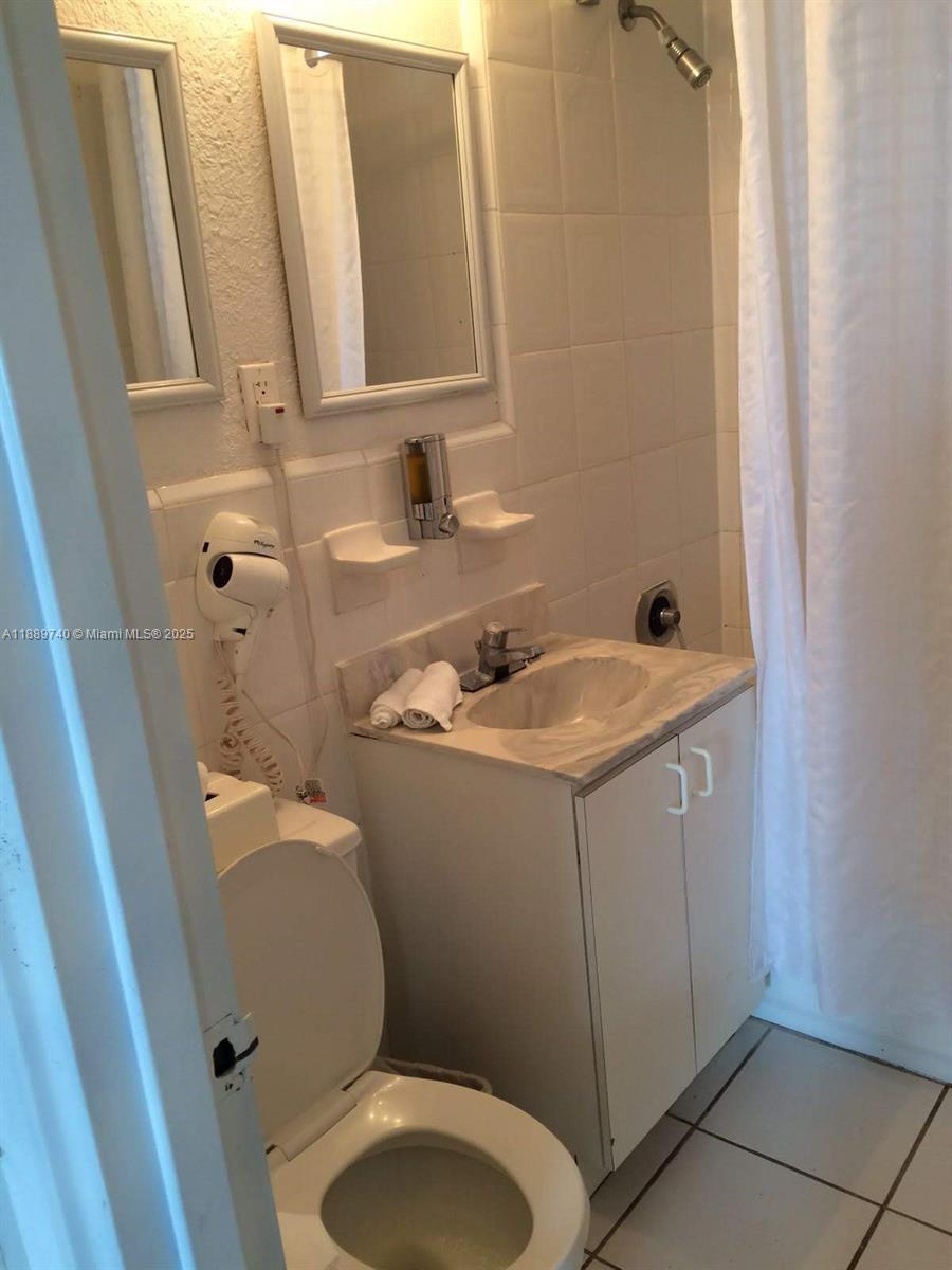 6345 Collins Avenue, Unit 937 Miami Beach, FL 33141 - Photo 14 of 27 a bathroom with a sink a toilet and a mirror