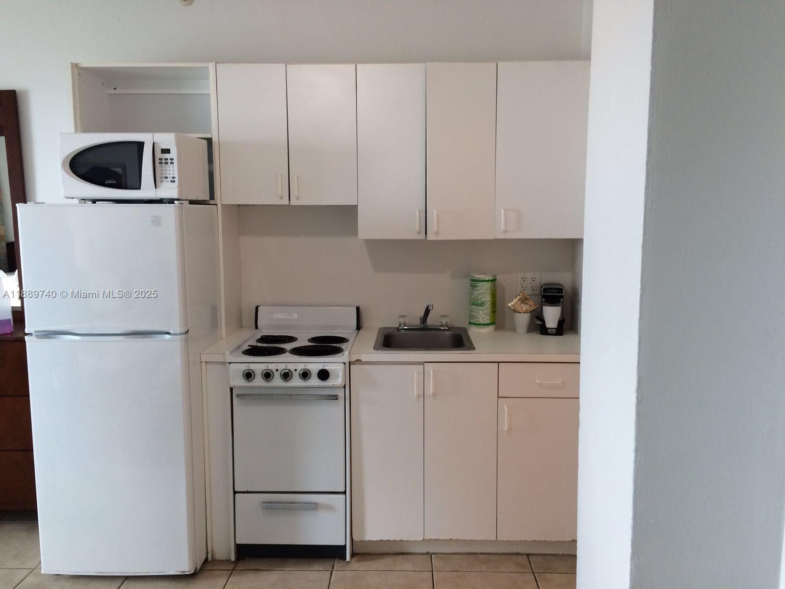 6345 Collins Avenue, Unit 937 Miami Beach, FL 33141 - Photo 27 of 27 a kitchen with white cabinets and white appliances