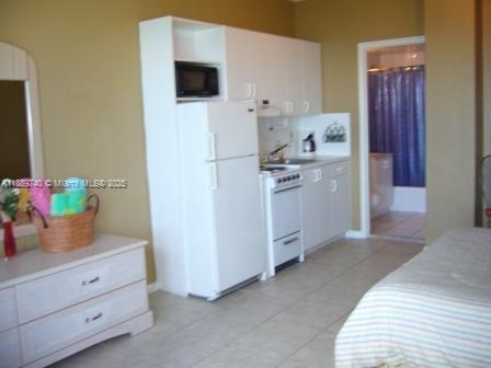 6345 Collins Avenue, Unit 937 Miami Beach, FL 33141 - Photo 4 of 27 a kitchen with white cabinets and white appliances
