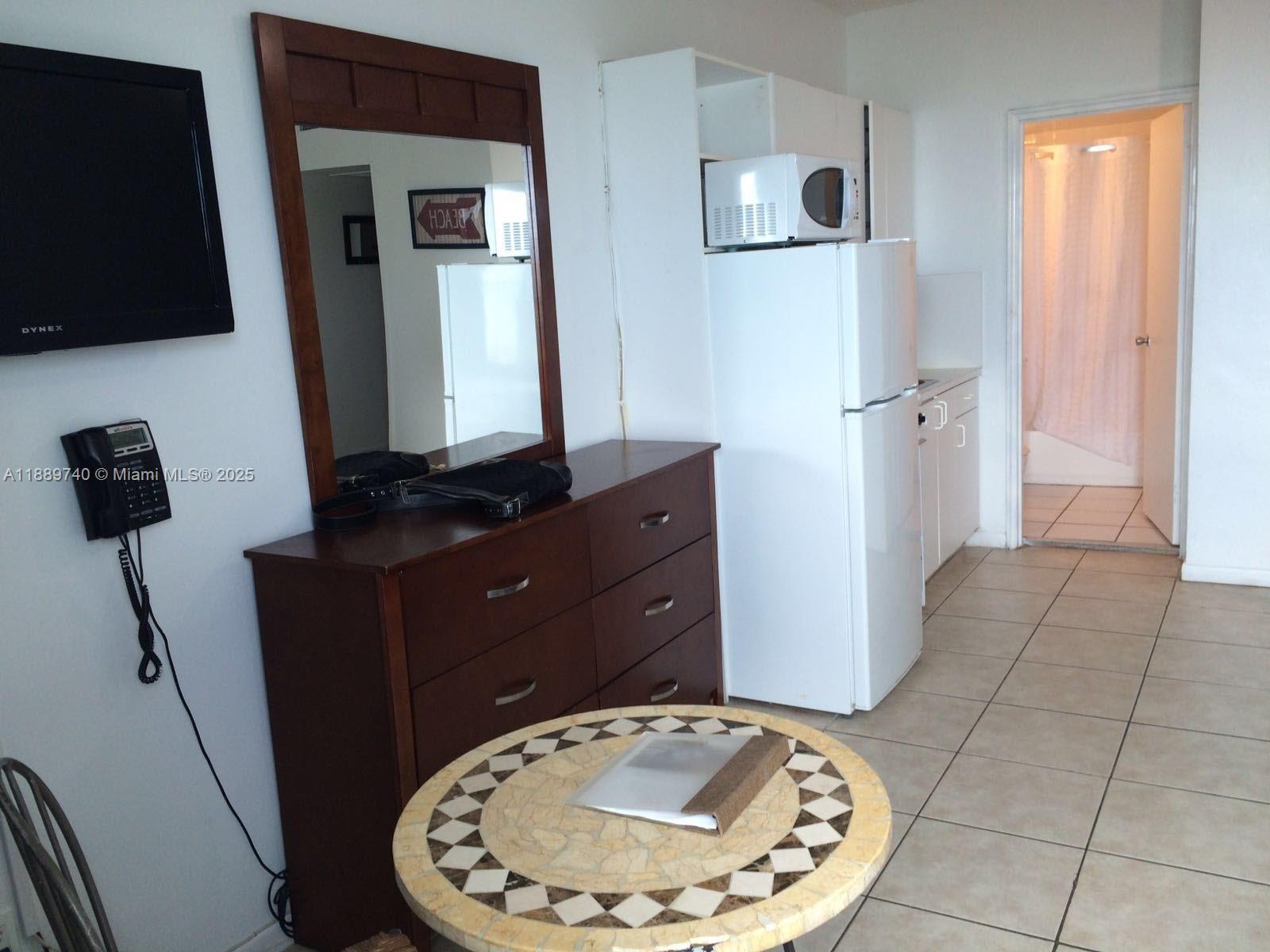 6345 Collins Avenue, Unit 937 Miami Beach, FL 33141 - Photo 8 of 27 a room with painting on the wall and a mirror