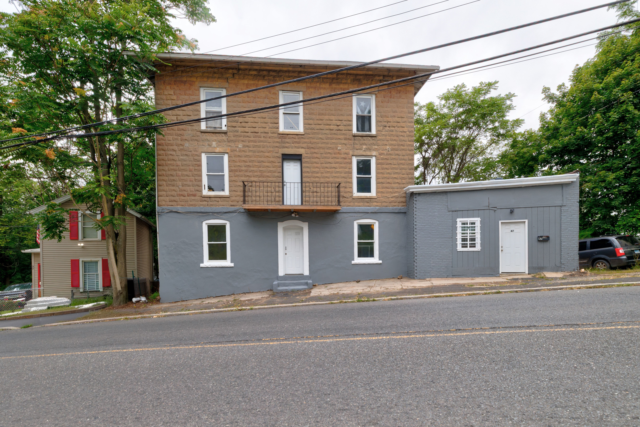 45 Long Hill Road, Unit 1L Waterbury, CT 06704 - Photo 1 of 1 a front view of a house with a road