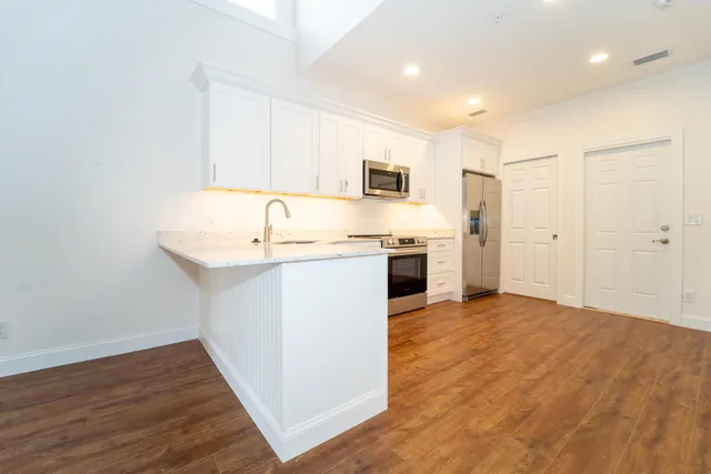a kitchen with stainless steel appliances granite countertop a sink stove and refrigerator