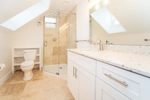 a bathroom with a granite countertop sink mirror vanity and toilet