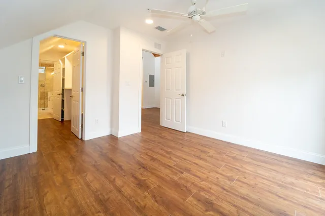 a view of a room with wooden floor and a ceiling fan
