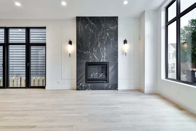 a view of an empty room with a fireplace and a window