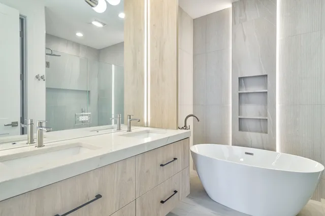 a bathroom with a double vanity sink a mirror and a bathtub