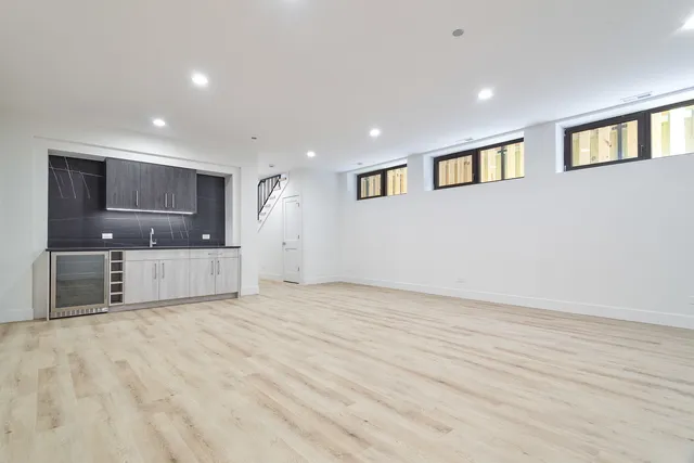 a view of a big room with wooden floor and a large window