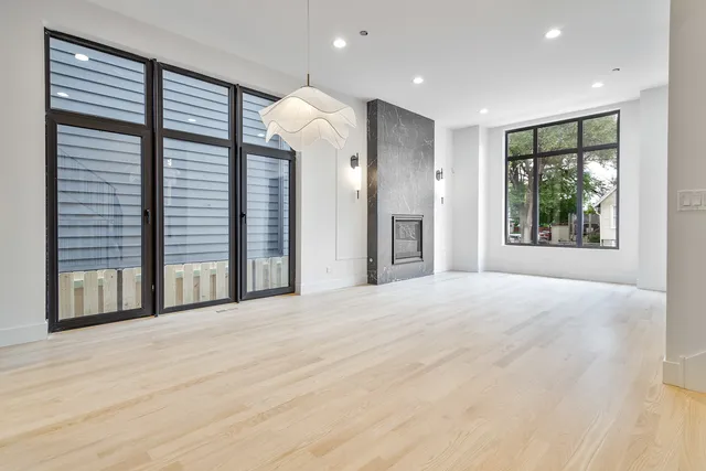 a view of an empty room with a window and kitchen view