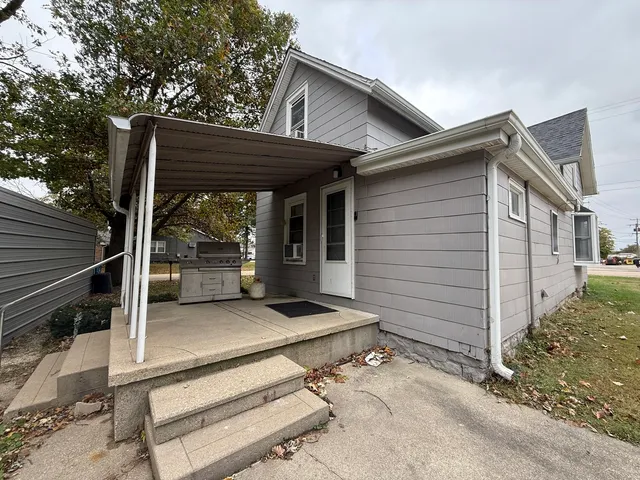 a view of a house with a large window and wooden fence