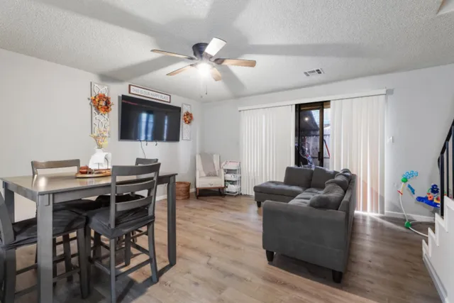a living room with furniture a wooden floor and chandelier