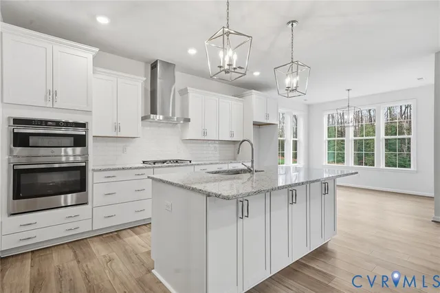 a kitchen with stainless steel appliances granite countertop a stove and cabinets