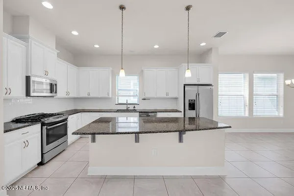 a view of a kitchen with an empty space and a window