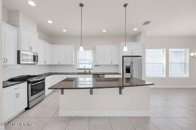 61 Spindrift Court St. Augustine, FL 32092 - Photo 32 of 61 a kitchen with granite countertop a stove a sink a counter space and cabinets
