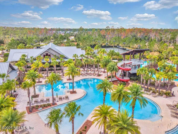 a view of a swimming pool with a lounge chair and palm trees