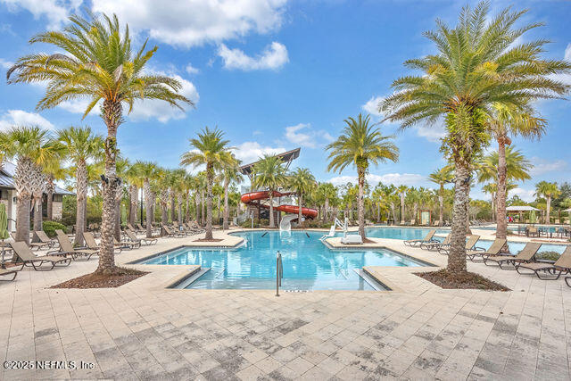 61 Spindrift Court St. Augustine, FL 32092 - Photo 7 of 61 a view of a swimming pool with a lounge chair and palm trees