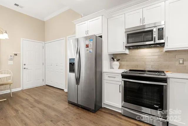 a kitchen with stainless steel appliances a stove a microwave and a hard wood floors