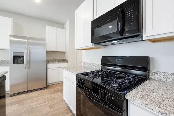 a kitchen with stainless steel appliances granite countertop a stove and a microwave