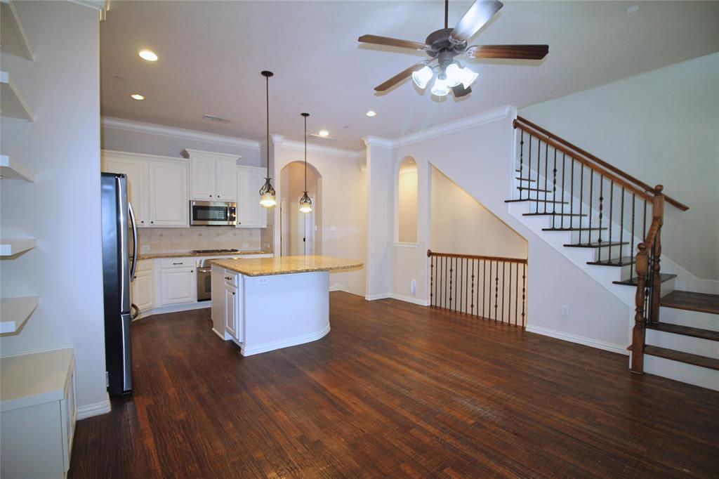 528 Tuscan Drive Irving, TX 75039 - Photo 12 of 40 Kitchen with a center island, decorative light fixtures, tasteful backsplash, white cabinetry, and ornamental molding