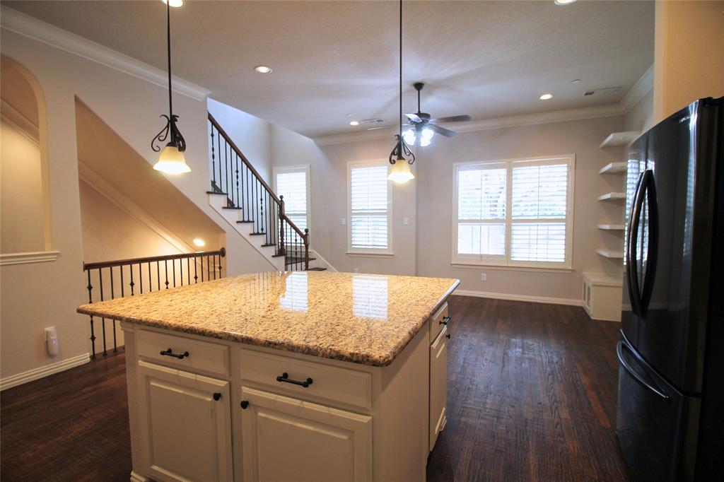 528 Tuscan Drive Irving, TX 75039 - Photo 13 of 40 Kitchen with freestanding refrigerator, crown molding, dark wood-style flooring, light stone countertops, and white cabinets