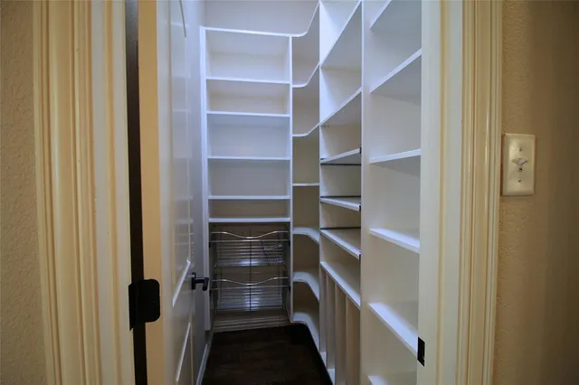 a view of walk in closet with wooden floor