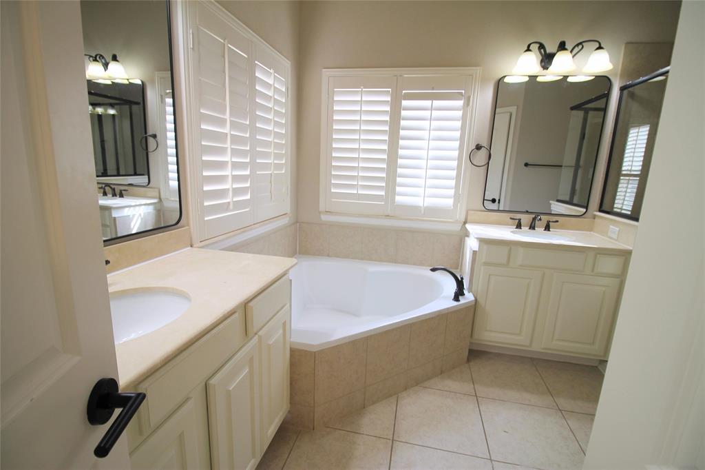 528 Tuscan Drive Irving, TX 75039 - Photo 28 of 40 Full bathroom featuring two vanities, a garden tub, and light tile patterned flooring