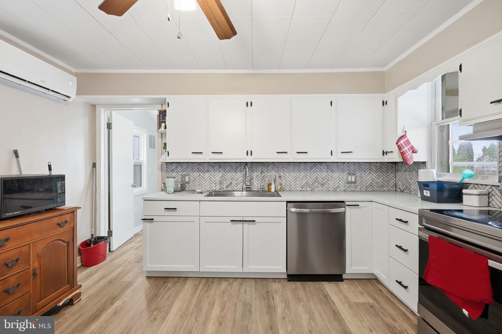 108 New Holland Avenue Reading, PA 19607 - Photo 12 of 66 a kitchen with stainless steel appliances granite countertop a stove top oven a sink dishwasher and white cabinets with wooden floor