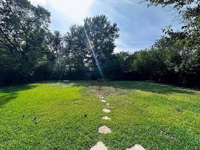 a view of yard with swimming pool and green space