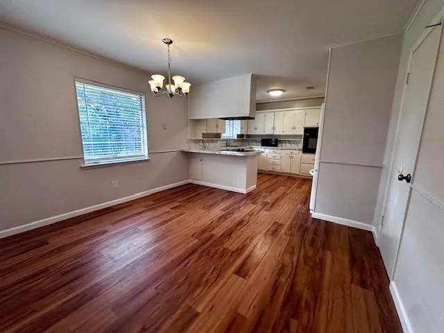 a view of a kitchen with wooden floor and a sink