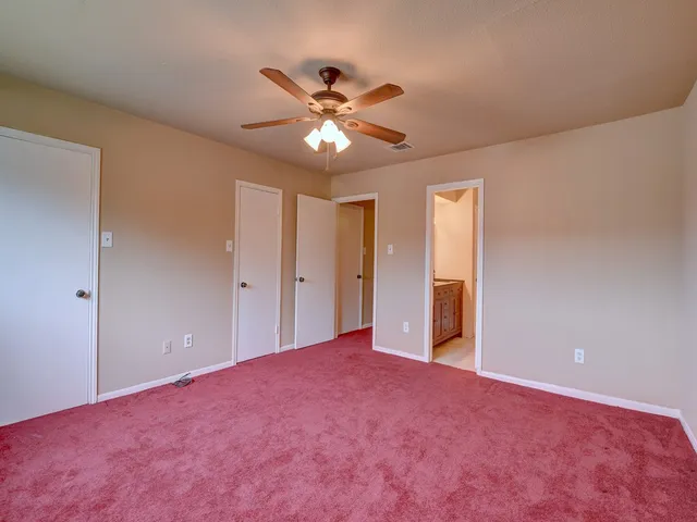 a view of an empty room with a ceiling fan