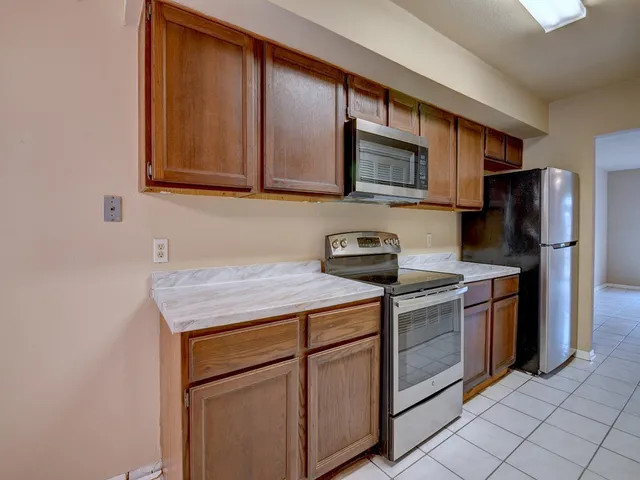 a kitchen with stainless steel appliances granite countertop a stove microwave and refrigerator