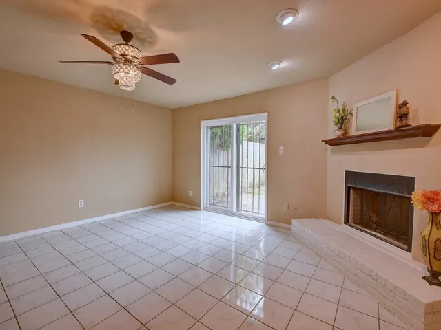 a view of an empty room with glass door and a fireplace
