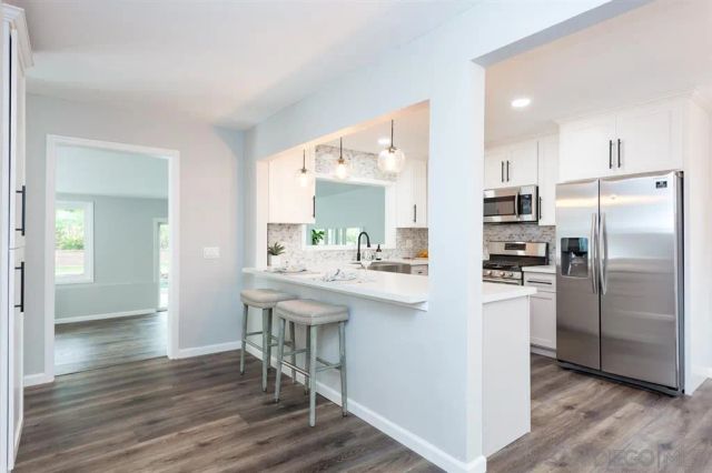 a kitchen with kitchen island a sink stove and refrigerator