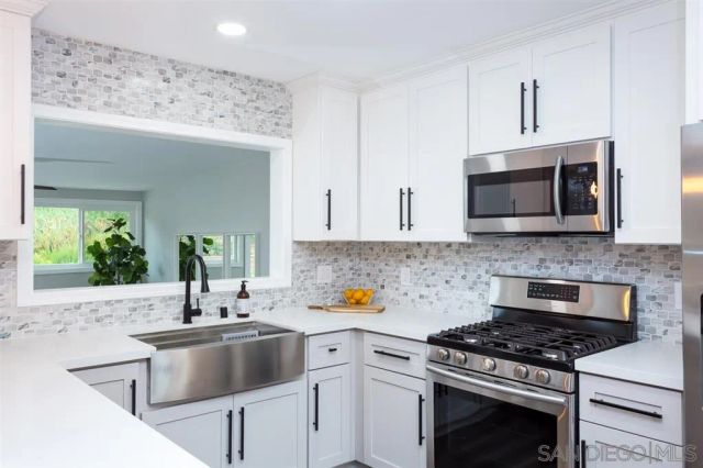 a kitchen with stainless steel appliances a stove a sink and a microwave