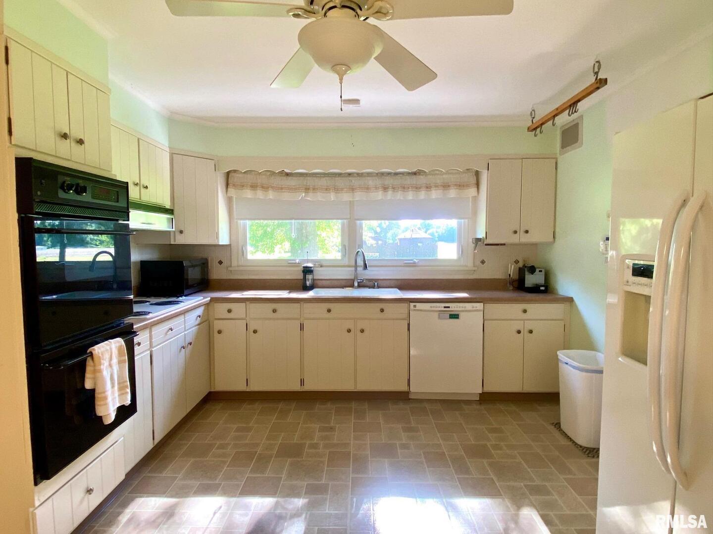 807 West Market Street Christopher, IL 62822 - Photo 10 of 57 a kitchen with a sink cabinets stainless steel appliances and a window
