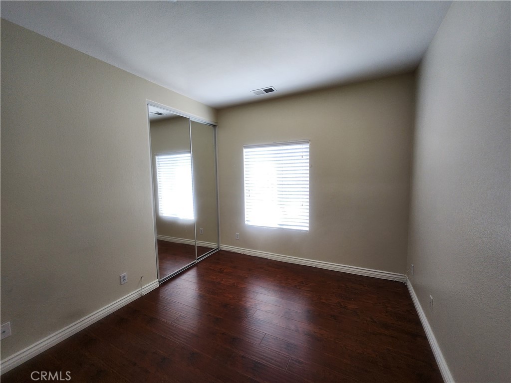 7331 Shelby Place, Unit U43 Rancho Cucamonga, CA 91739 - Photo 13 of 26 an empty room with wooden floor and windows