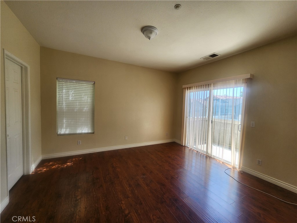7331 Shelby Place, Unit U43 Rancho Cucamonga, CA 91739 - Photo 18 of 26 a view of an empty room with wooden floor and a window