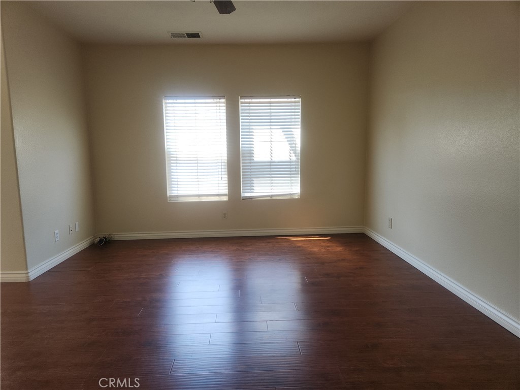 7331 Shelby Place, Unit U43 Rancho Cucamonga, CA 91739 - Photo 3 of 26 an empty room with wooden floor and windows