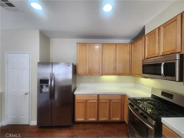 a kitchen with granite countertop wooden cabinets stainless steel appliances and a window