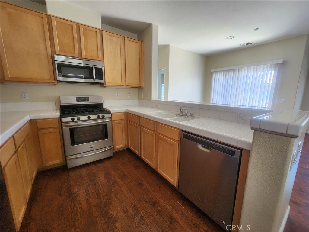 7331 Shelby Place, Unit U43 Rancho Cucamonga, CA 91739 - Photo 8 of 26 a kitchen with stainless steel appliances granite countertop a stove a sink and a microwave