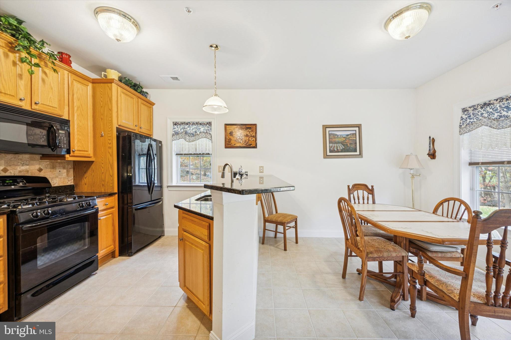 3000 Village Way, Unit 3101 Boothwyn, PA 19061 - Photo 5 of 29 a kitchen with stainless steel appliances granite countertop a stove top oven a sink a dining table and chairs