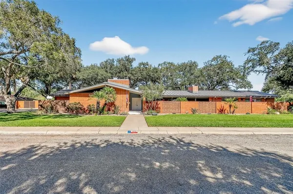 a front view of a house with a yard and lake view