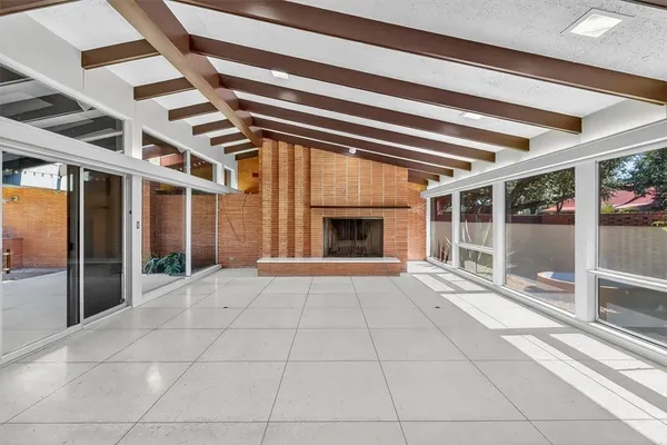 a view of an empty room with a fireplace and window