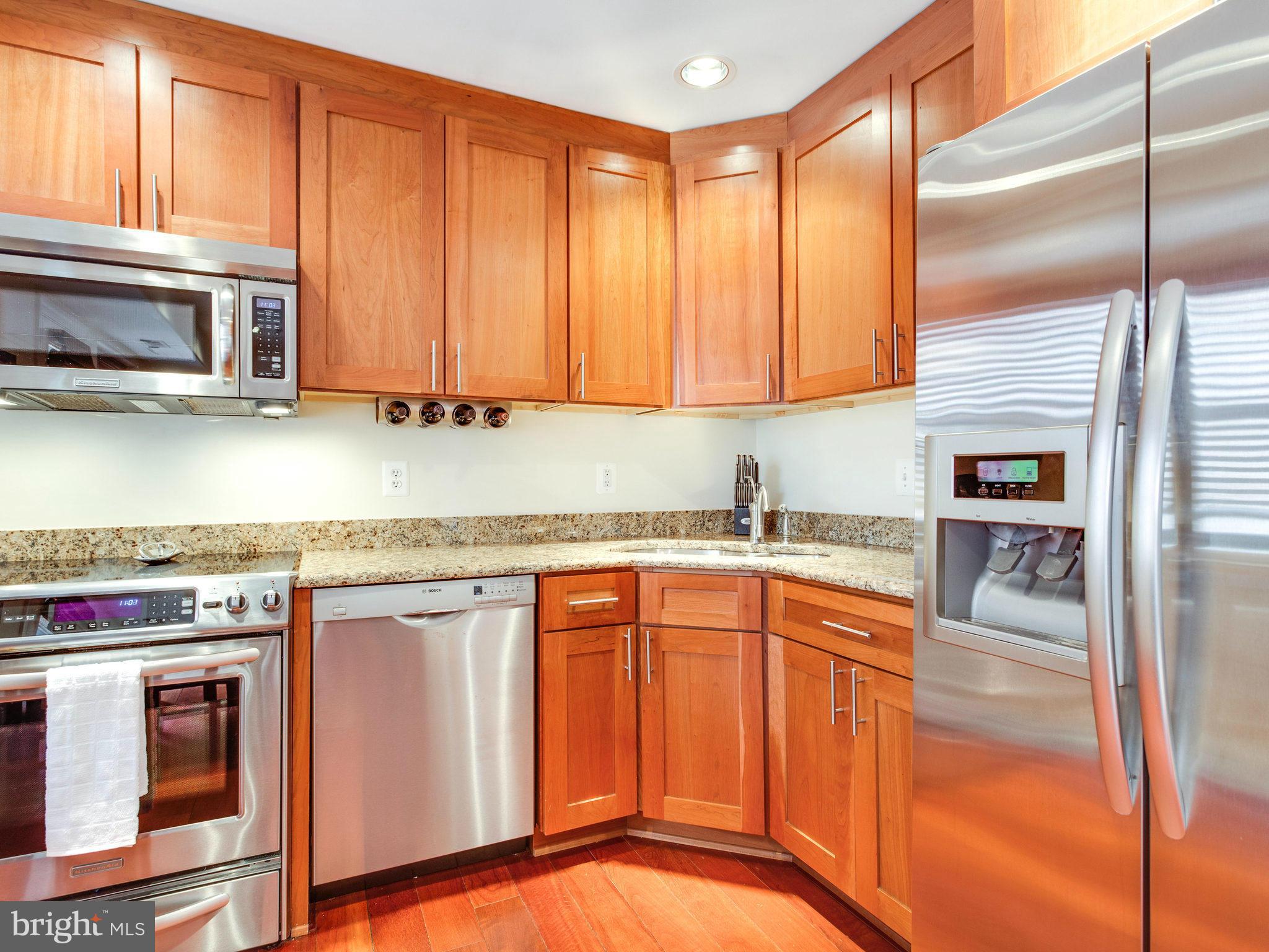 1354 Euclid Street Northwest, Unit B402 Washington, DC 20009 - Photo 10 of 30 a kitchen with stainless steel appliances granite countertop a stove a sink and a microwave