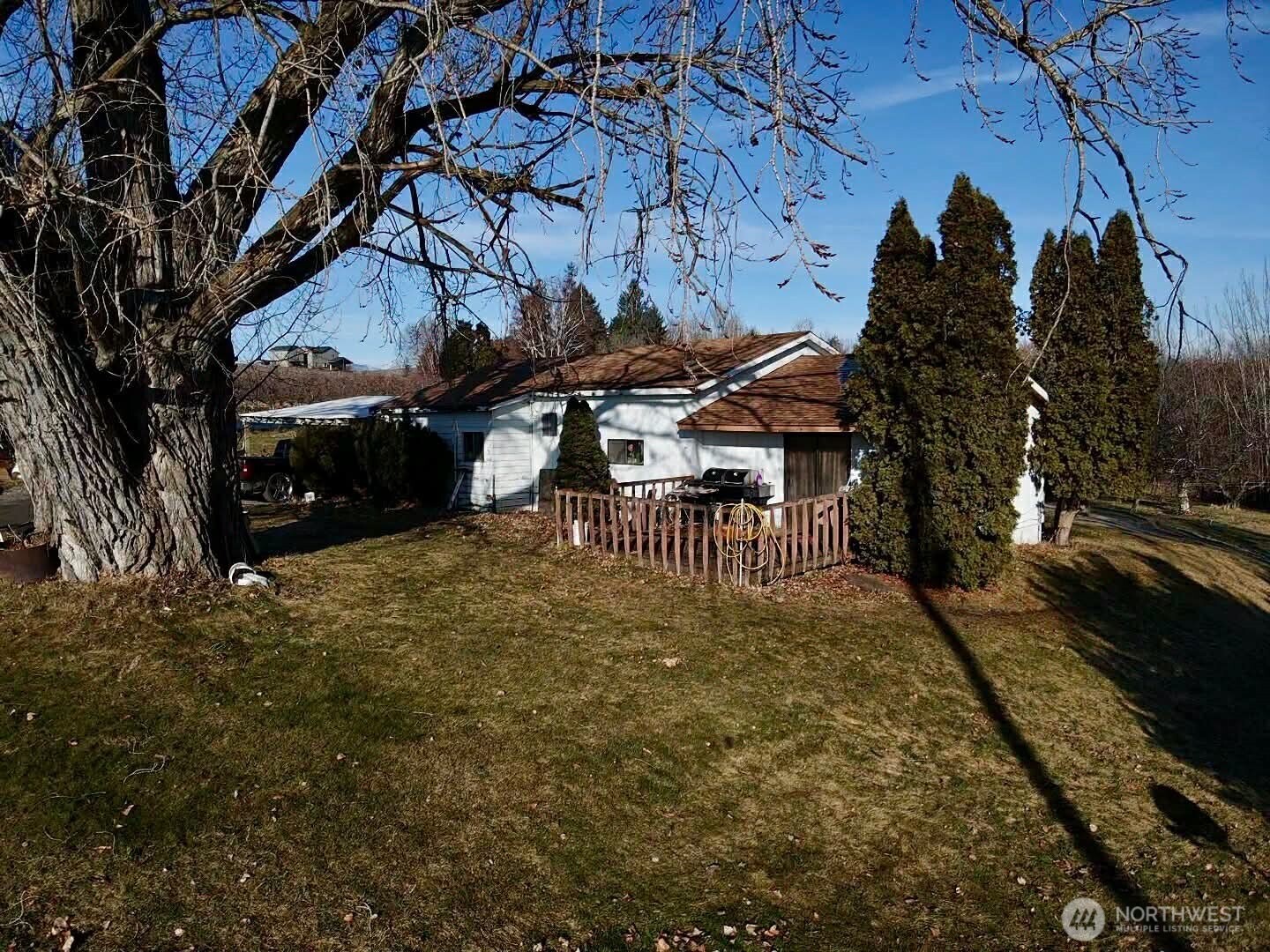 223 Old Riverside Highway Omak, WA 98841 - Photo 12 of 22 a backyard of a house with table and chairs under an umbrella