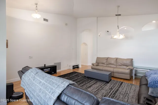 a very nice looking kitchen with granite countertop a stove a sink a dining table and chairs with wooden floor