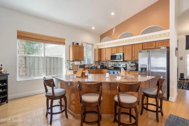 a kitchen with stainless steel appliances granite countertop a refrigerator a stove a sink and a microwave