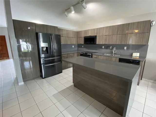 a kitchen with stainless steel appliances a refrigerator and a stove top oven